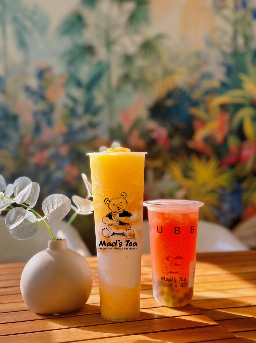 Mango slushie and strawberry bubble tea on a sunny café table